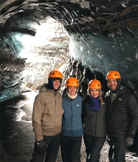 Brandie posing with her husband and friends in a cave