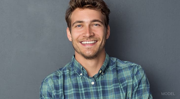 Man with arms crossed smiling