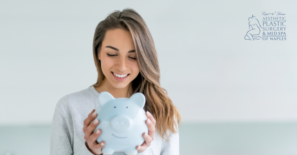 Woman holding a piggy bank with a smile on her face (MODEL) Kent V. Hasen, MD Logo