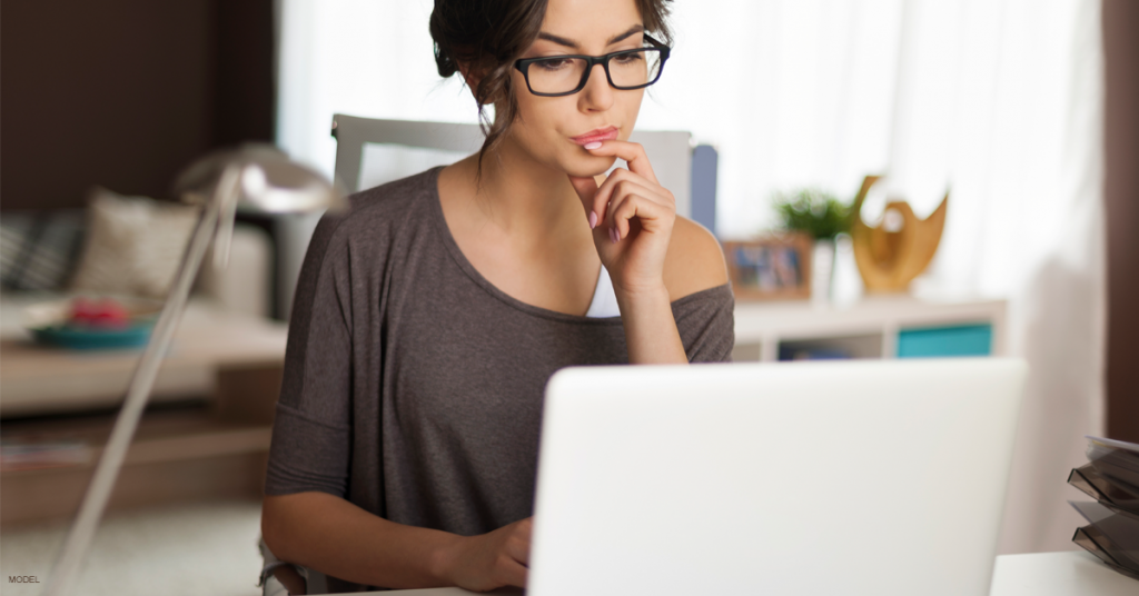 Woman wearing glasses looking at laptop screen
