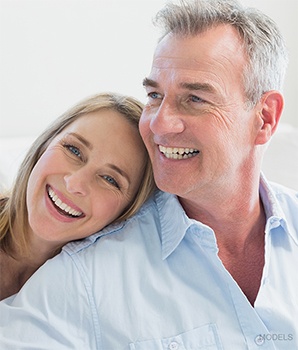 Mature couple sitting down with woman's head on man's shoulder