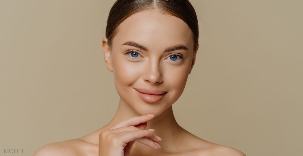 Women smiling and touching her chin (model)