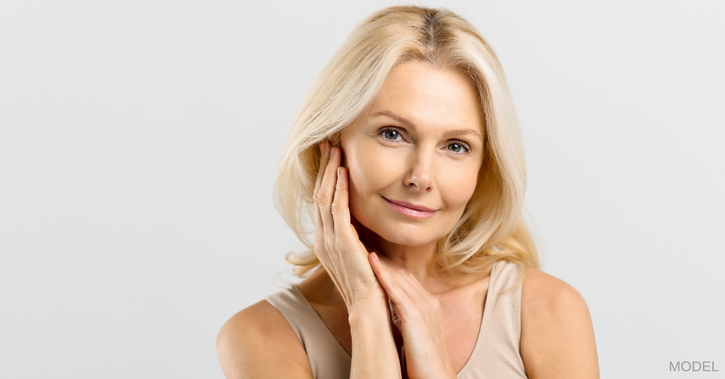 Older woman touching rejuvenated face (model)