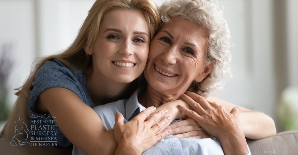 mother in her 60s and daughter in her 30s hugging (models)