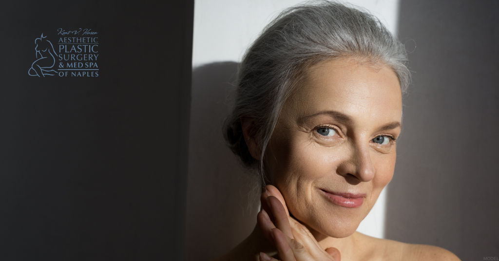 Mature woman with her hands touching her chin (model)